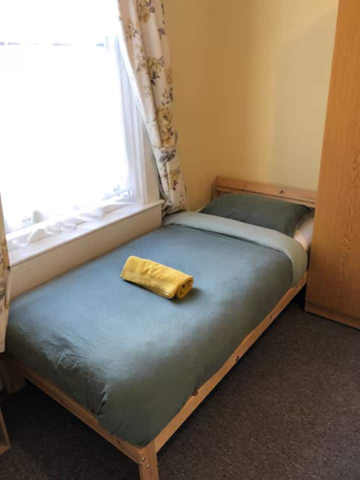 غرفة نوم مشرقة ومريحة مع سرير مزدوج واحد وبياضات مريحة وأجواء هادئة مثالية للراحة والاسترخاء.
