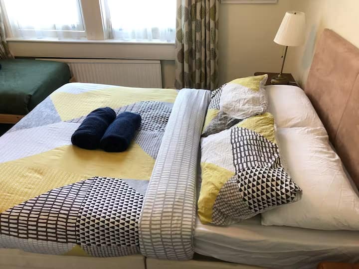 غرفة نوم مريحة مع سرير مزدوج واحد، وأغطية سرير ناعمة، وأجواء هادئة - مثالية لقضاء ليلة مريحة.
