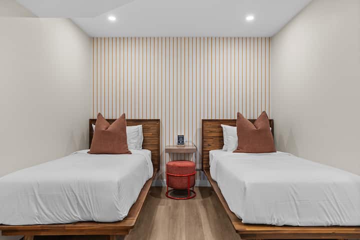 חדר זוגי מוארת בהשראת הקיץ, עם מצעים פרימיום, כריות מלון פיירמונט, חדר רחצה צמוד פרטי וארון מלא המצויד במתלים למזוודות, קולבים ומאווררי חימום/קירור לנוחות נוספת.