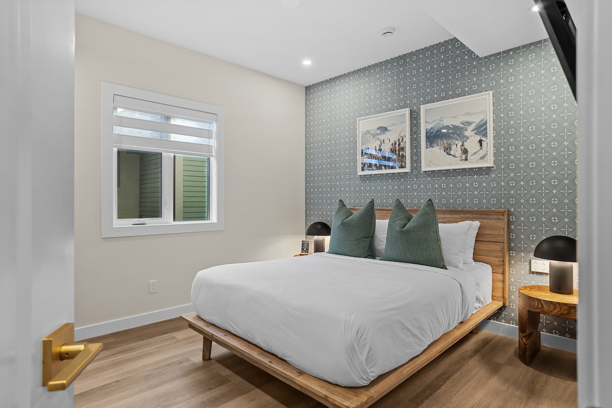 Спалня с двойно легло с зимна тематика с висококачествени спално бельо, възглавници от хотел Fairmont, самостоятелен душ, смарт телевизор за филмови вечери и пълен гардероб с поставки за багаж, закачалки и вентилатори за отопление/охлаждане за допълнителен комфорт.