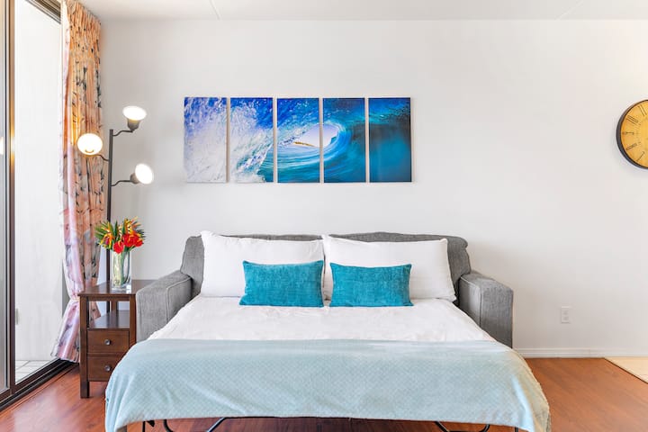 Cómodo sofá cama con obras de arte inspiradas en el mar e iluminación suave para noches relajantes