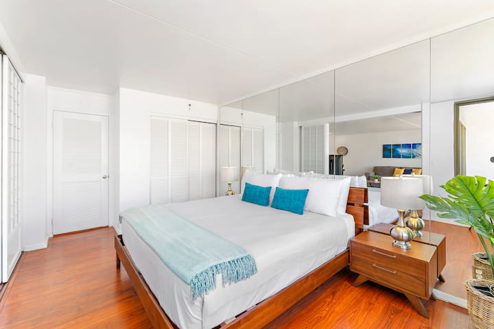 Tranquilo dormitorio con mesitas de noche, armario y luz natural suave