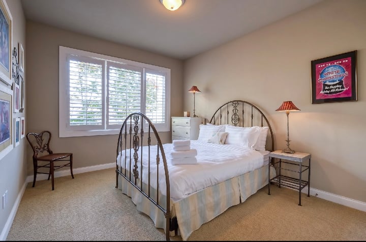 Habitación Charming Queen: esta habitación bellamente decorada cuenta con una cama queen de metal ornamentado y mucha luz natural de grandes ventanales. Ofrece un refugio tranquilo con sábanas suaves y toallas limpias y frescas apiladas y listas para tu llegada.