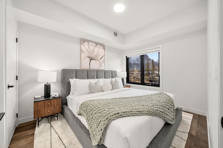 Chumba cha kulala cha msingi kinachovutia kilichobuniwa kwa ajili ya starehe, kikiwa na mwanga mzuri, mapambo ya kisasa na mandhari ya kuvutia ya nje.