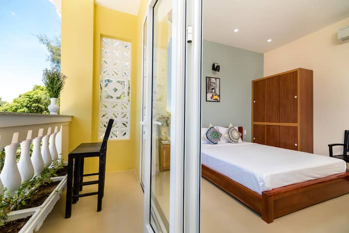 Una habitación acogedora y luminosa con balcón privado y muebles de madera natural. A poca distancia a pie de la playa, ofrece una estancia relajante y cómoda.