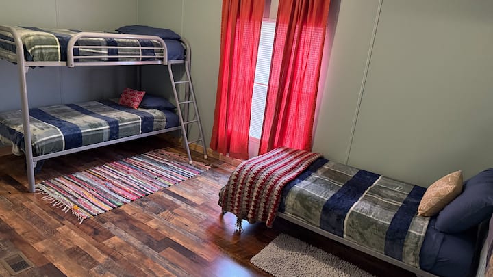 双人床上铺床，配备额外的单人床和衣柜……这是第三间卧室，在右侧，走廊尽头，当您进入前门时……