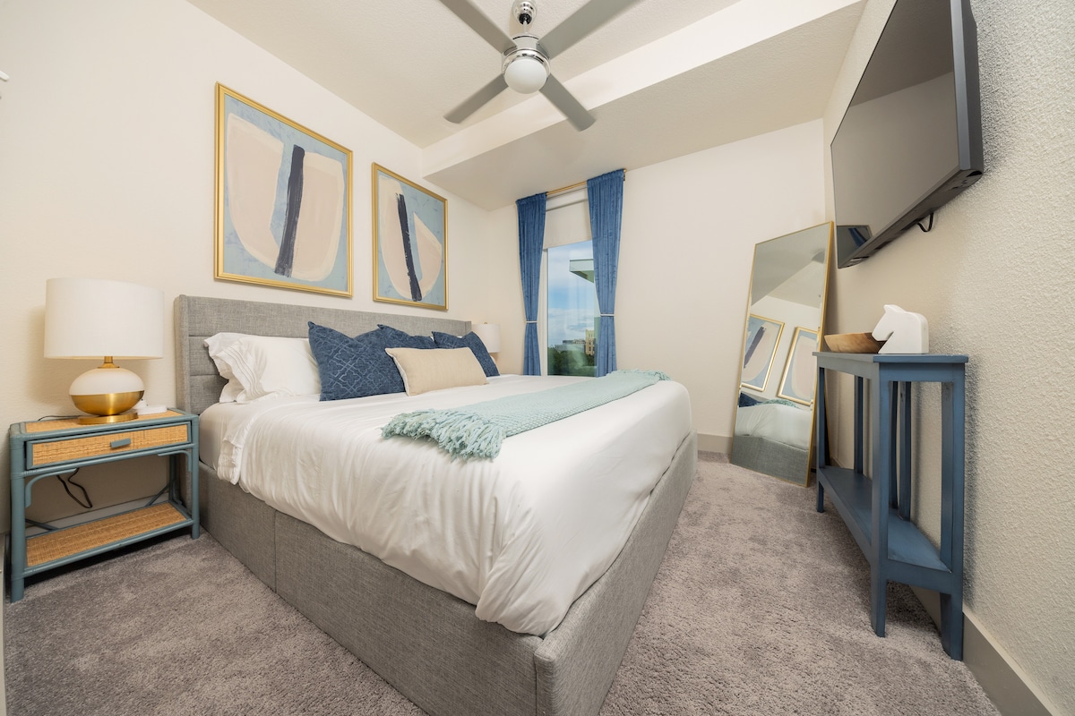 Потопете се в релаксация в тази спокойна основна спалня, предназначена за дълбока, непрекъсната почивка. Централният елемент е плюшено двойно легло с матрак от хотелски клас, свежи бели чаршафи и подредени възглавници в успокояващи крайбрежни тонове.  