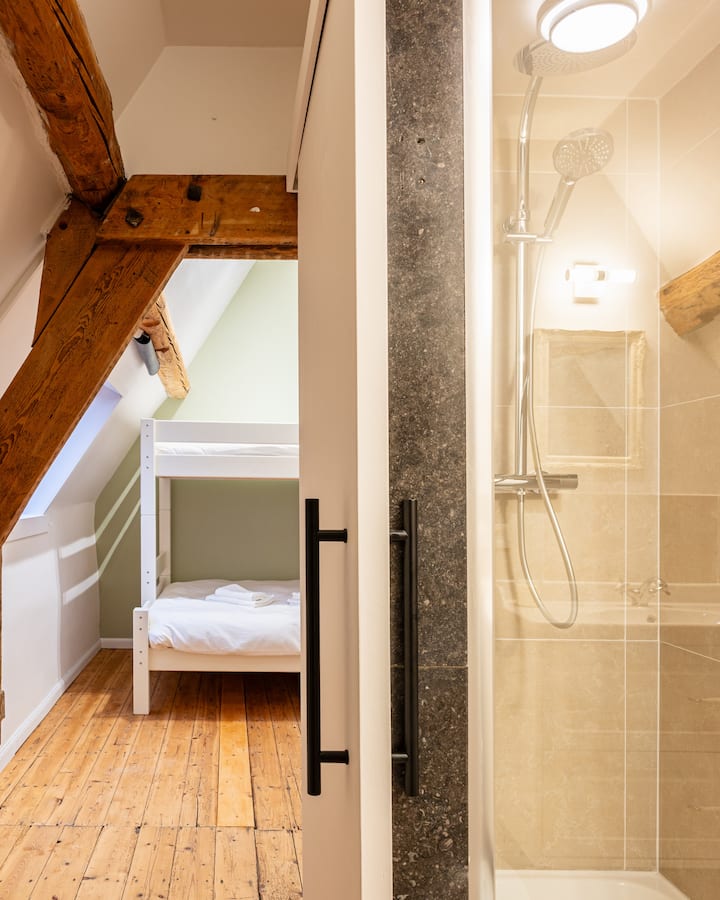 Deze ruime kamer bevindt zich op de bovenste verdieping en heeft een bed van 160×200 en een bed van 120×200, die geschikt is voor 2 volwassenen en 2 kinderen of maximaal 3 volwassenen. Het heeft ook een eigen doucheruimte met wastafel en toilet.