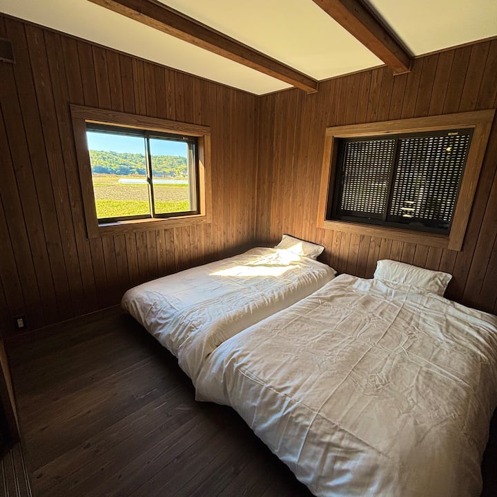A bedroom where you can feel the warmth of wood.
The window overlooks a pastoral landscape and a peaceful morning.