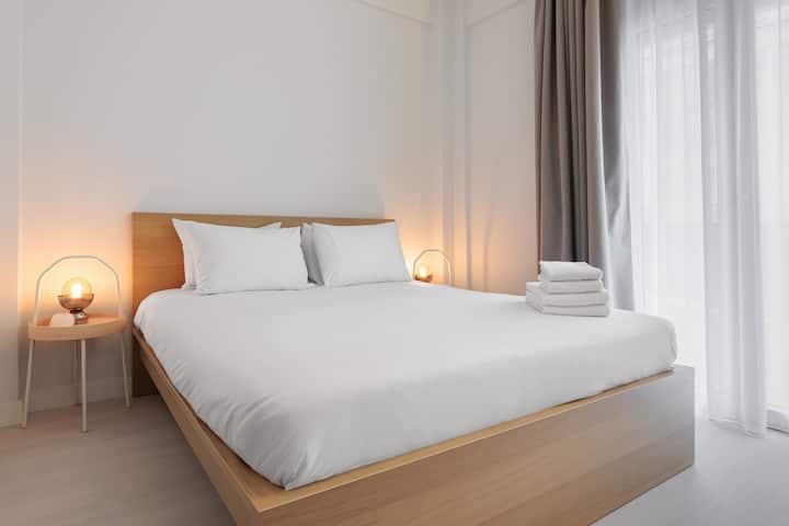 Cada dormitorio en Valerie by halu! ofrece un ambiente sereno con una cama tamaño queen, iluminación suave y cálidos detalles de madera. Una combinación perfecta de comodidad y diseño minimalista para una noche de sueño reparador.