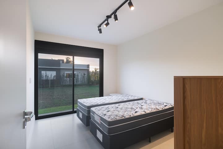 ห้องสวีทพร้อมเตียงเดี่ยว 2 เตียงและประตูใหญ่ไปยังสวน 