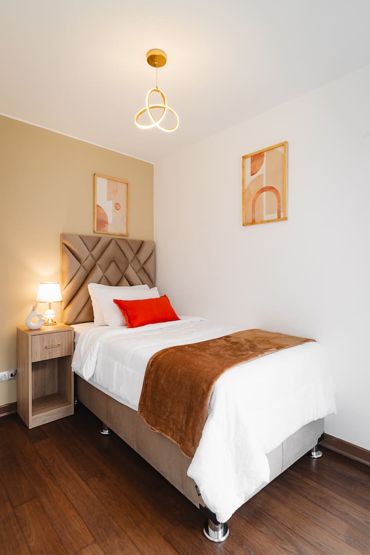 Удобна соба со голем единечен кревет, идеална за одмор. Неговиот топол и модерен дизајн е надополнет со голем плакар и декоративни детали кои создаваат удобна и функционална атмосфера за вашиот престој.