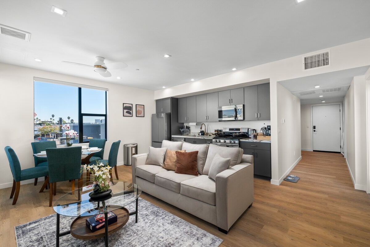 Светла, приветлива всекидневна със смарт телевизор и уютен секционен диван – идеалното място за почивка след ден на плажа.