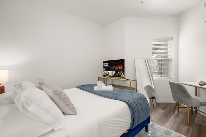 يتميز ملاذك الخاص بسرير كبير الحجم فاخر مع بياضات ناعمة وبطانية باللون الأزرق الداكن، وتوازنه مساحة عمل أنيقة وتلفزيون ذكي للبث. تخلق الأسقف العالية والفن التجريدي الهادئ ملاذًا هادئًا في الحرم الجامعي الغربي مثاليًا للراحة والإنتاجية.