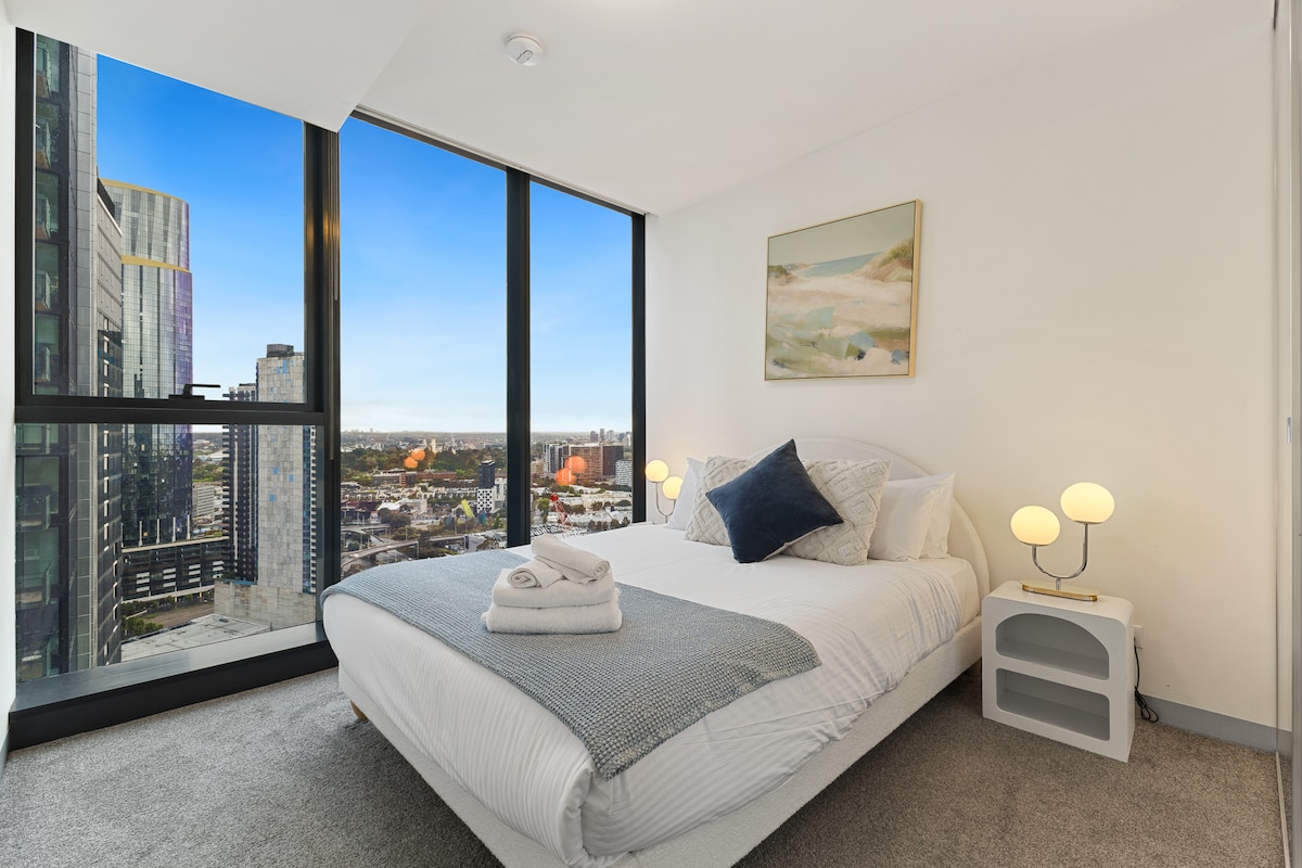 Derde slaapkamer met queensize bed en grote ramen.