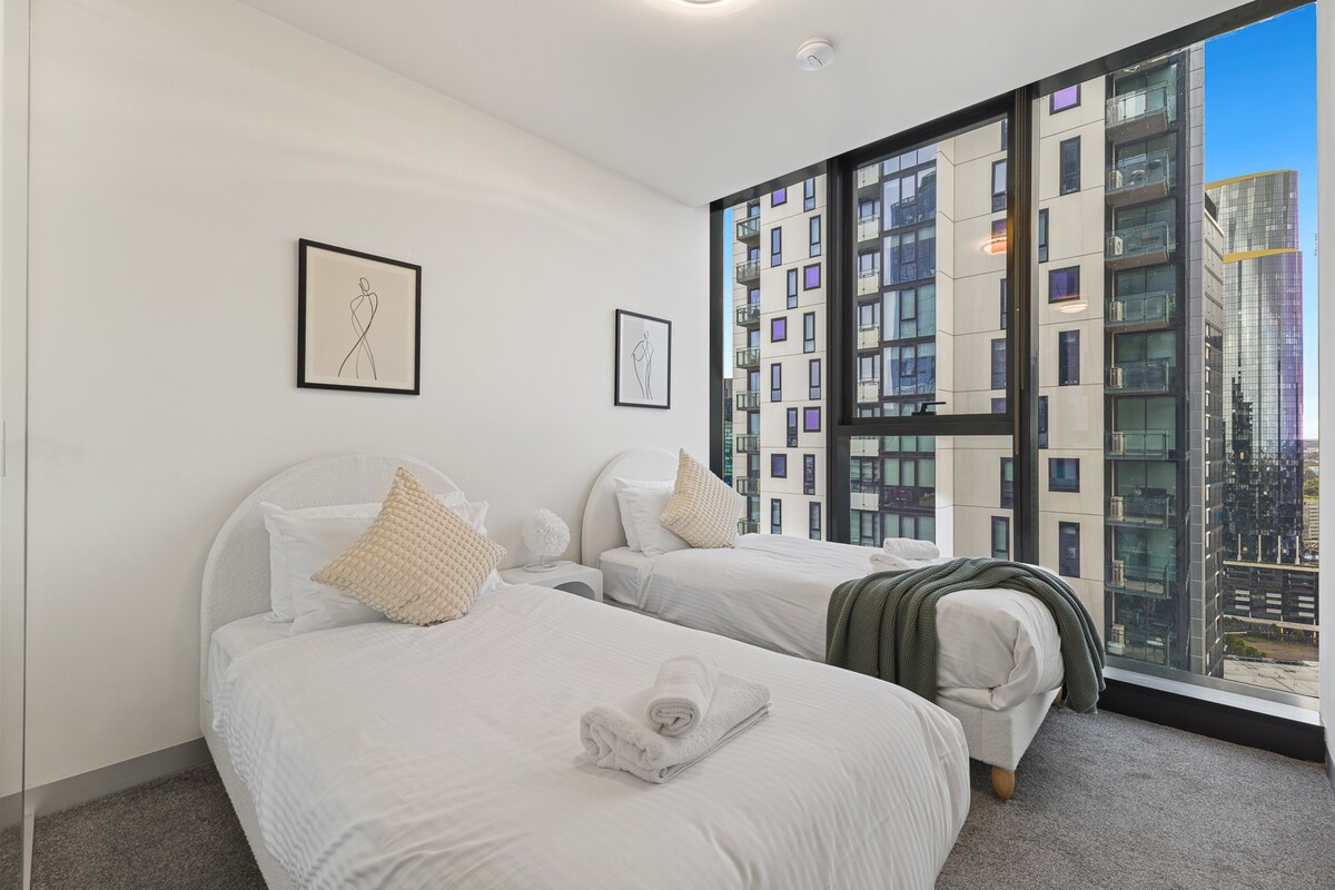 Tweede slaapkamer met twee eenpersoonsbedden en een stijlvolle inrichting.