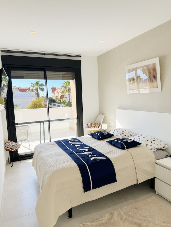 Stylishly decorated double bedroom with spacious fitted wardrobes and air conditioning.