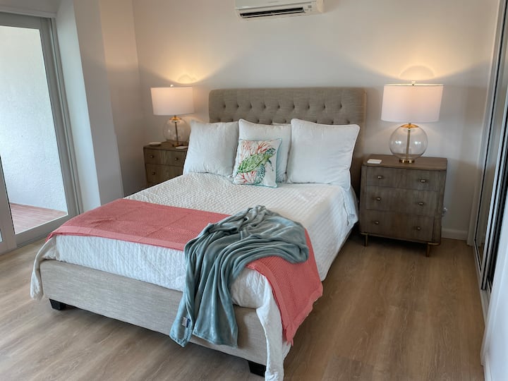 Spálňa s manželskou posteľou Queen, nočnými stolíkmi, komodou, televízorom, šatníkom a uzamykateľnou skrinkou. 