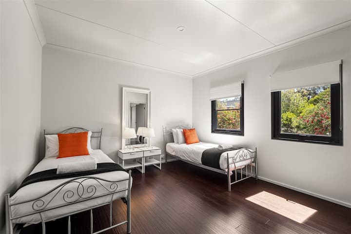 Светлата двокреветна соба со два одделни кревета, мека постелнина и поглед кон градината е совршена за пријателите или семејството кои бараат свое мирно катче.