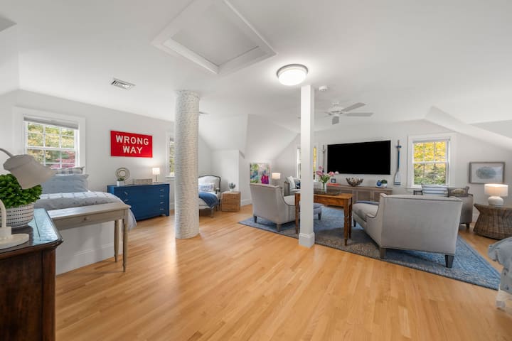 2nd floor bedroom/living area with four twin beds, TV & a comfy seating space.