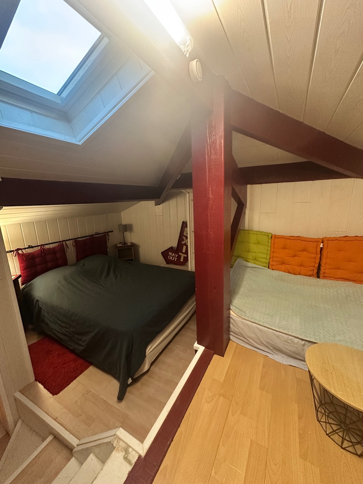 Šarmantna spavaća soba s krevetom od 140 cm, udobnim potkrovljem, okupana prirodnim svjetlom zahvaljujući krovnom prozoru. S izloženim gredama, svijetlim zidovima i detaljima u boji, nudi toplu atmosferu, idealnu za opuštajući boravak