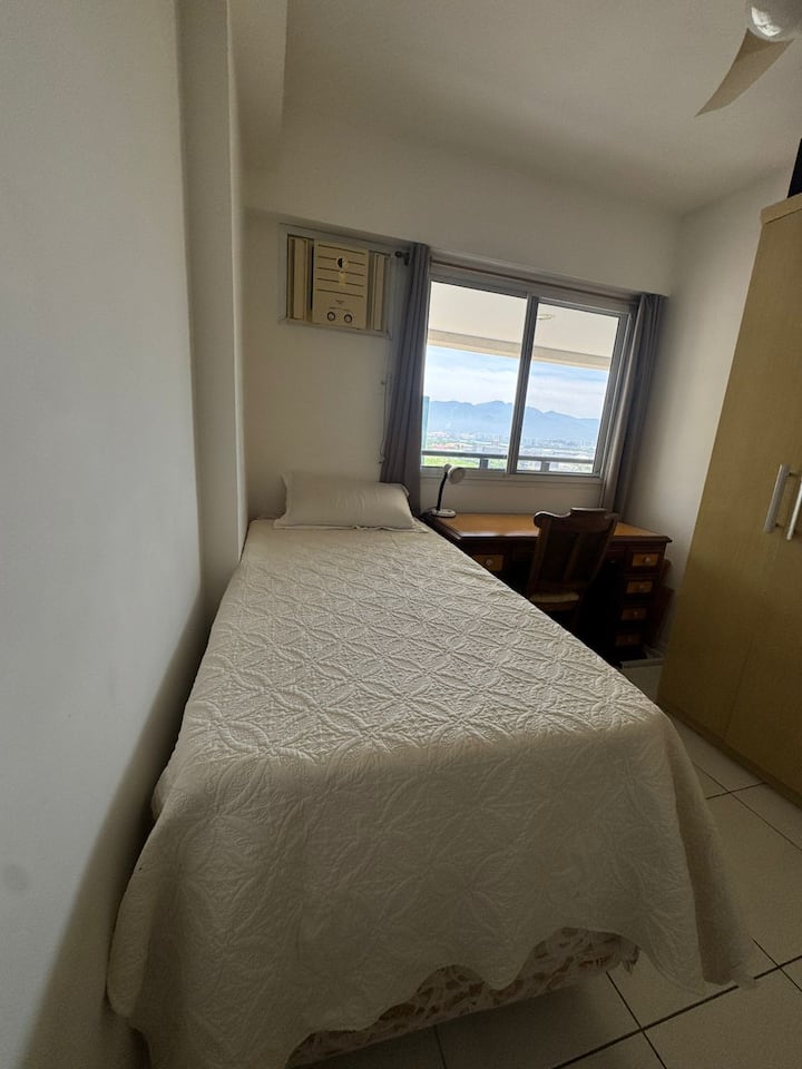 Dhomë gjumi me një krevat tek dhe një dyshek shtesë.