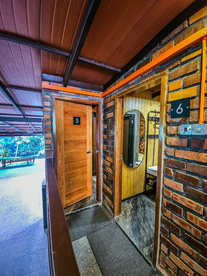 Room 5: Above the Action. Your wood door opens right onto the balcony overlooking the main common and dining spaces.