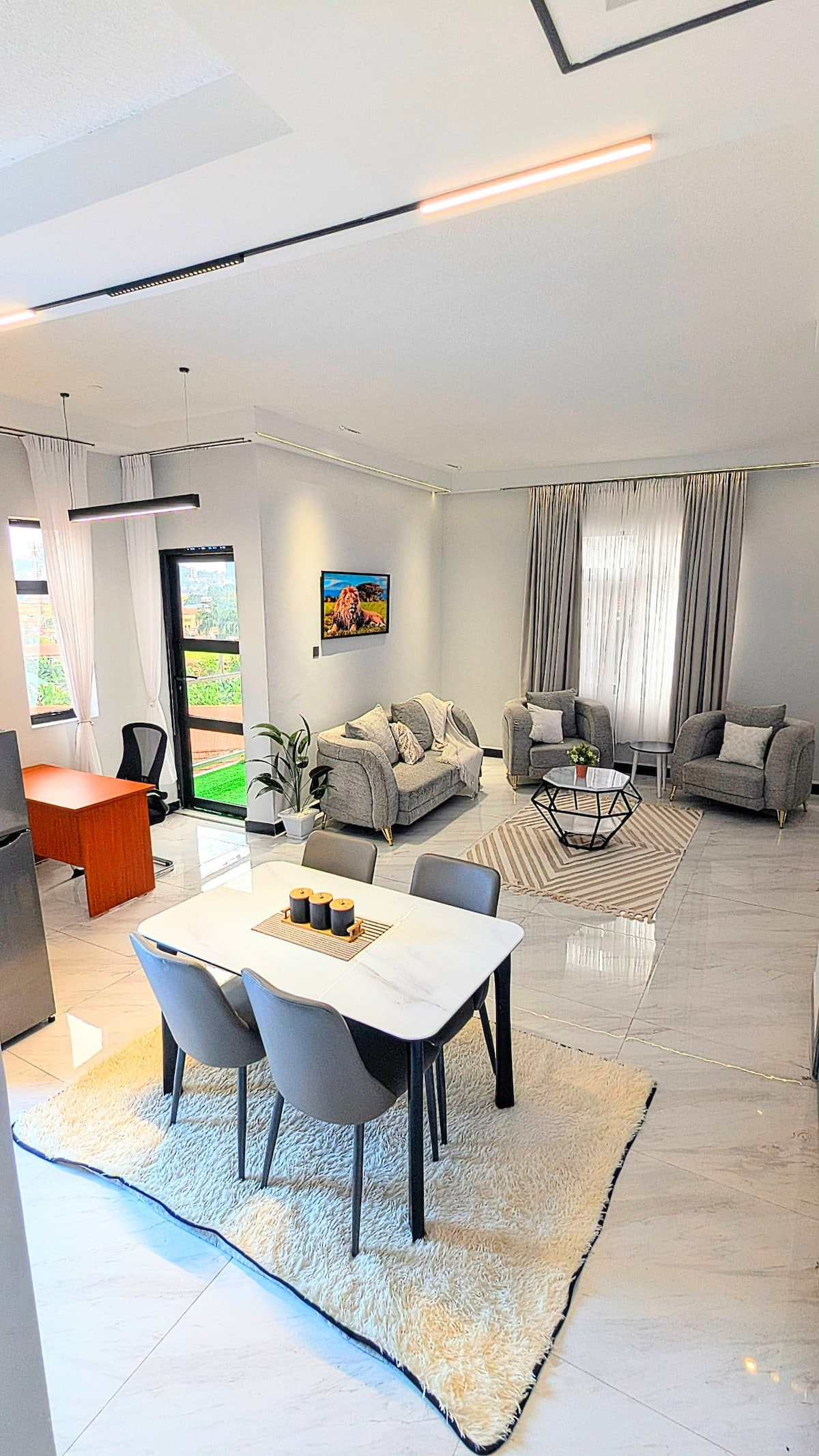 ห้องนั่งเล่นที่สว่างและหรูหรา พื้นที่มีการตกแต่งที่ทันสมัย แสงสว่างนุ่มนวล หน้าต่างกว้างขึ้นที่นำแสงธรรมชาติเข้ามาและประตูที่เปิดไปยังระเบียงส่วนตัวที่มีวิวที่สวยงาม