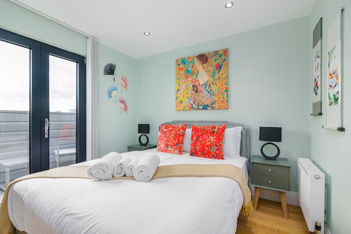 ห้องนอนใหญ่ที่เงียบสงบพร้อมเครื่องนอนหรูหราทางเข้าระเบียงและแสงไฟอ่อนๆ — ผ่อนคลายหลังจากวันที่วุ่นวายในลอนดอน