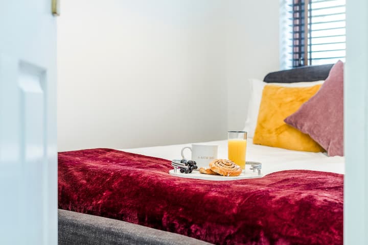 在这间温馨的切姆斯福德卧室中放松身心！ 豪华特大号床，配有豪华的栗色盖毯、柔软的白色床单、充满活力的芥末色和勃艮第色装饰枕头。 卷起的白色毛巾、新鲜的兰花、木制百叶窗—纯粹的舒适和贴心的细节等待着您。