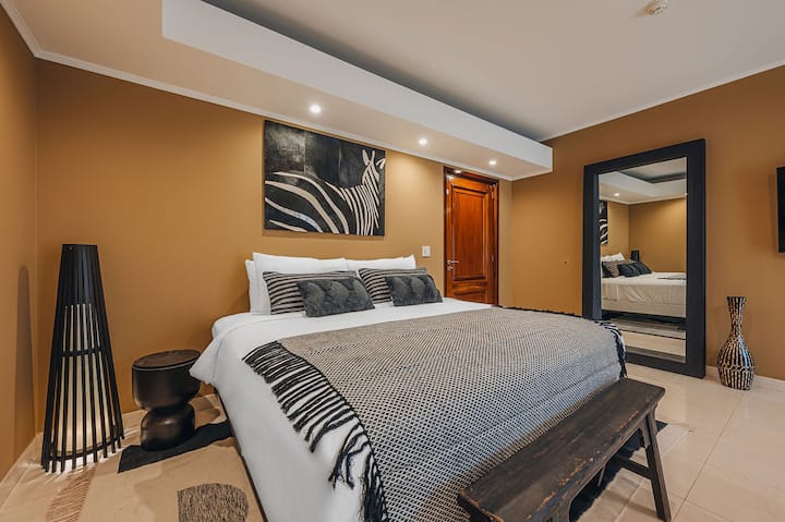 Bersantai di tempat persemayaman yang elegan. Nikmati tempat tidur mewah dan dekorasi yang terinspirasi Afrika.