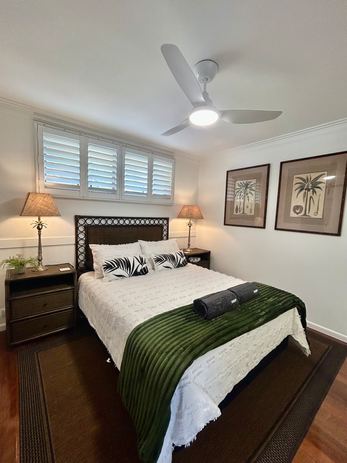 توفر غرفة النوم الرئيسية شعورًا بالاسترخاء في الجزيرة الاستوائية، وتتميز بمصابيح الأناناس، والأعمال الفنية الاستوائية المستوحاة من الطراز العتيق، ومراوح السقف، وخزانة ملابس عاكسة من الأرض إلى السقف. يكمل الحمام الملحق المسكن، مما يوفر الراحة لإقامتك.