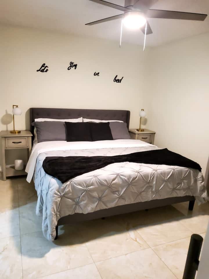 Chumba cha kulala cha msingi chenye kitanda kipana na chenye starehe, kilichoundwa kwa ajili ya ukaaji wa kupumzika. Sehemu maridadi na tulivu ya kupumzika na kupumzika.