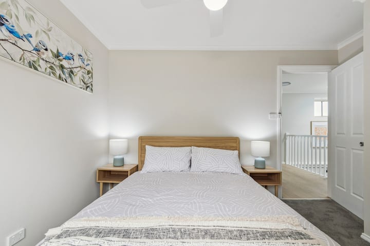 The third bedroom features a double bed dressed in crisp linens, soft lighting and direct access to a private balcony for quiet morning moments.