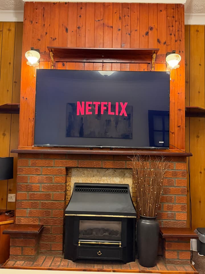 客厅配有壁挂式智能电视，装饰壁炉上方，为下班或观光后的夜晚营造温馨舒适的空间。