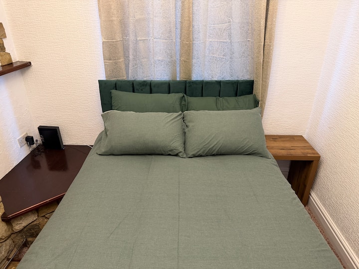 舒适的双人卧室，配备舒适的双人床、床头柜、柔和的照明和中性装饰，是安静的夜晚睡觉的理想选择。