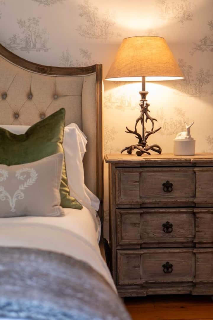 Chumba chetu chenye mandhari ya Kifaransa kuelekea katikati ya nyumba kina meko na kinaelekea uani wa jikoni. Sehemu yenye uwiano mzuri na tulivu ya kupumzika. Ingia kwenye milango miwili ya bafu tamu zaidi la chumbani lenye bomba la mvua. 