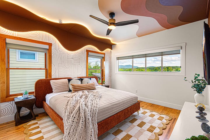 Este dormitorio principal luminoso y acogedor cuenta con una lujosa cama tamaño king y un baño privado, ¡todo con increíbles vistas a las montañas Blue Ridge!