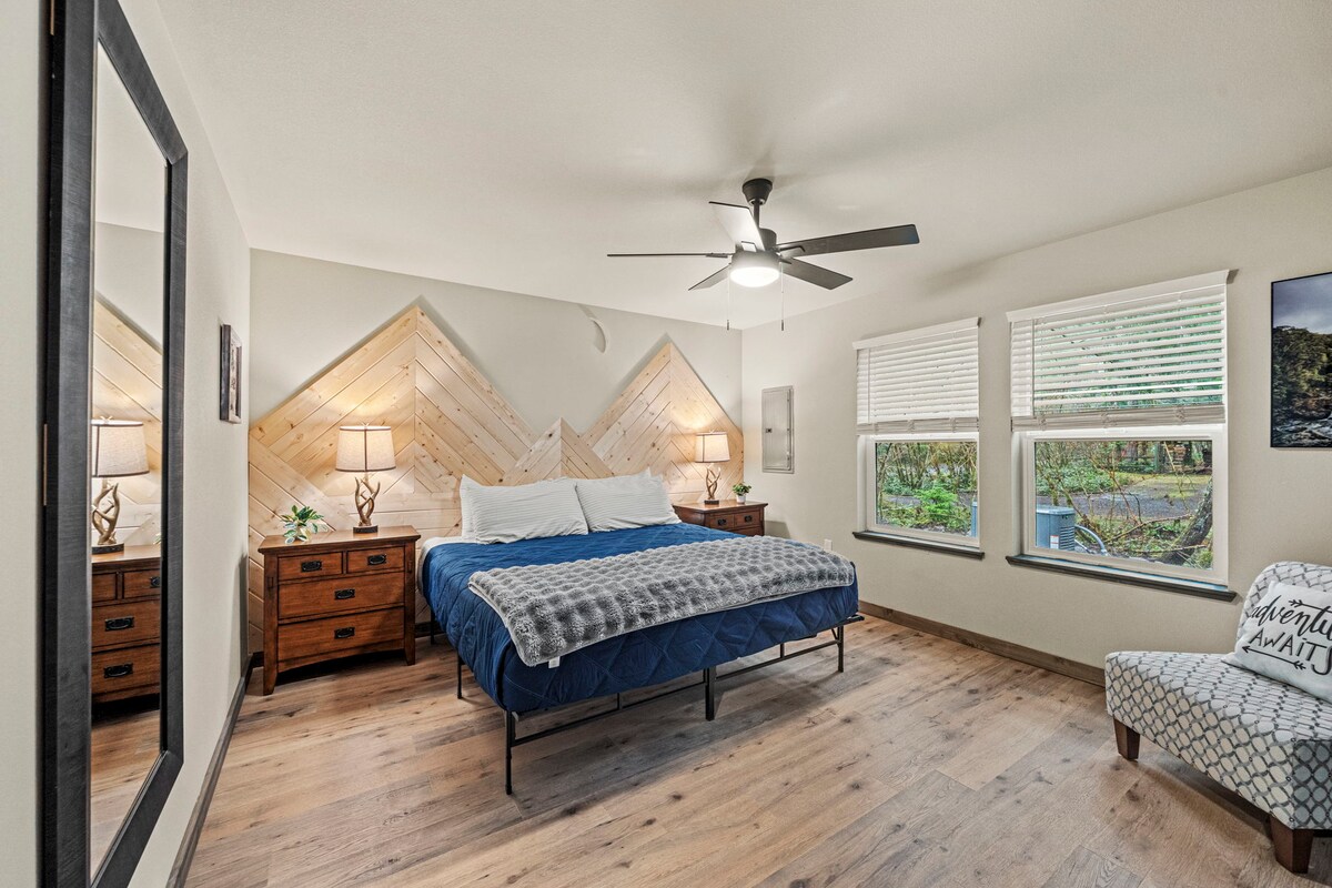 Lákavá spálňa s manželskou posteľou King a špeciálnou drevenou stenou, skrinkou na bielizeň a súkromným kútikom na sedenie.