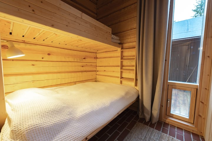 Perheystävällinen makuuhuone, jossa on parivuode ja ylimääräinen parviotyylinen kerrossänky.