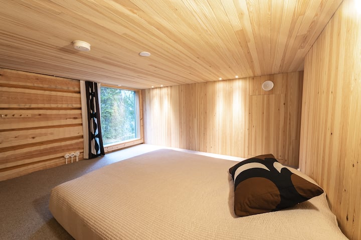 Parvimakuuhuone, jossa on pehmeä kokolattiamatto ja rauhalliset metsänäkymät.