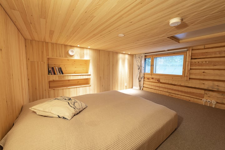 Toisessa parvihuoneessa on kodikkaat matot ja pieni kirjahylly hiljaisiin iltoihin.