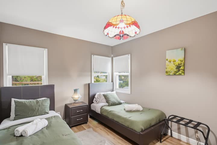 ห้องนอนแขกสว่างด้วยเตียงเดี่ยวสองเตียงที่สบาย เหมาะสำหรับเด็ก เพื่อน หรือเพื่อนร่วมทริปในการผ่อนคลาย 