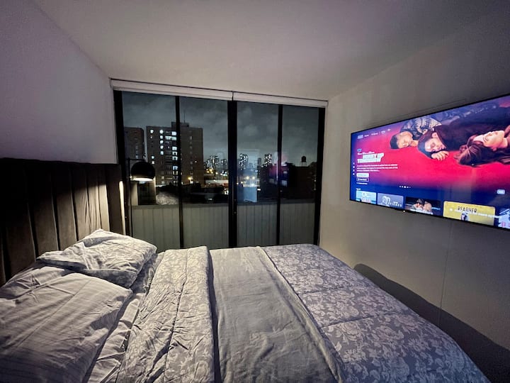 Queen size bed and 55" smart TV in the bedroom. 