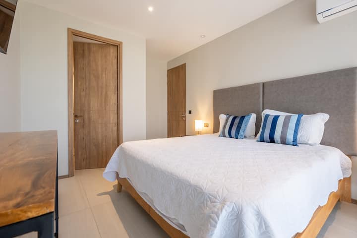 Amplia y elegante habitación con cama king, aire acondicionado, TV y baño privado. Perfecta para descansar y despertar con una hermosa vista.