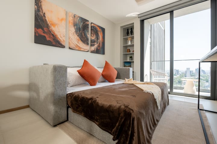 Relájate en esta sala con aire acondicionado y salida al balcón. Su sofá cama y decoración moderna crean un ambiente cómodo y relajante para cualquier momento del día.
