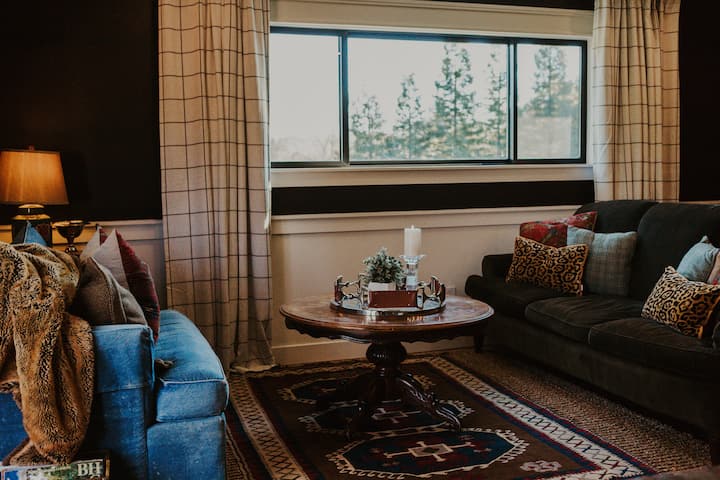 The living room brings together classic design and a functional layout, offering space to gather, unwind, or relax after a day exploring the farm and surrounding area, set alongside a double window with views of the property.
