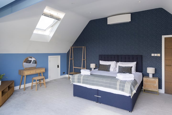 Elegant bedroom with a comfortable king-size bed, stylish décor, and soft lighting. A calm and inviting space, perfect for unwinding and enjoying a restful night’s sleep.