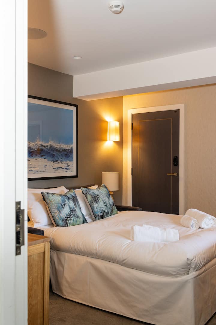 Comfortable and stylish bedroom with soft lighting and modern décor. A cosy, inviting space designed for relaxation and a restful night’s sleep.