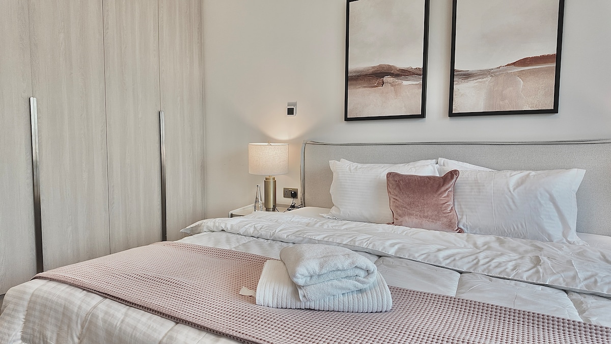 חדר שינה נוח עם מצעים פרימיום, תאורת לילה ועיצוב מודרני.